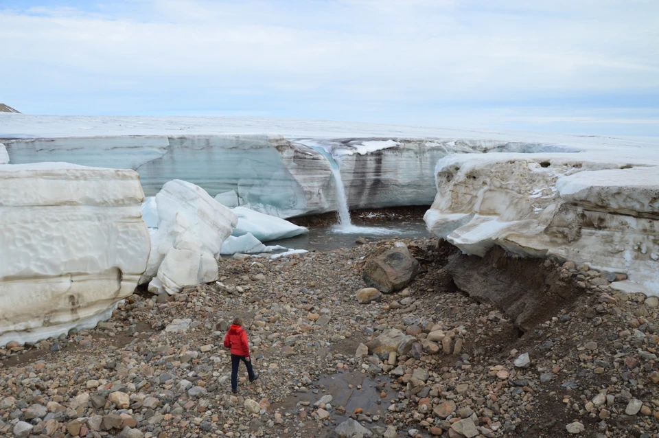 A river of melt water leaves a glacier in Greenland