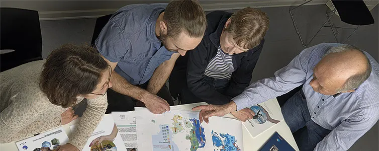 fire personer kigger på kort over dk