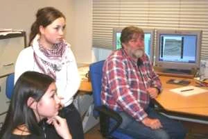 Agathe Møller og Kista Høegh lytter til, hvordan man indsamler seismiske data, efter at Torben Bidstrup fra GEUS har vist dem nogle af de oliegeologiske data fra Vestgrønland på computeren.