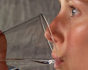 Kvinde, som drikker vand af glas