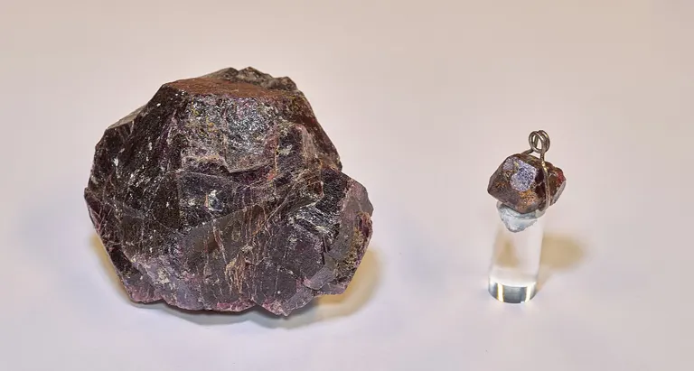 Rå granat ved siden af granatkrystal i smykke