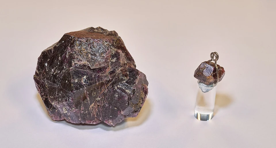 Rå granat ved siden af granatkrystal i smykke