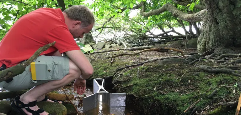 Mand som studerer et vandløbs kredsløb