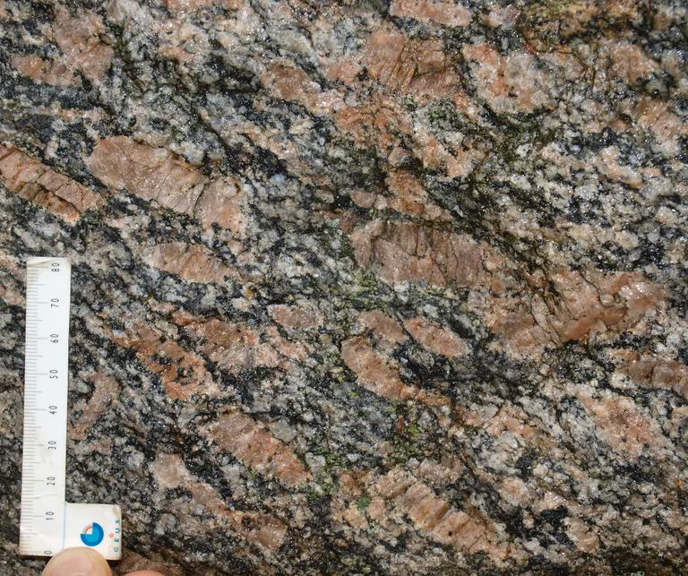 Tirslundstenen består af gnejsgranit med aflange kalifeldspatkrystaller