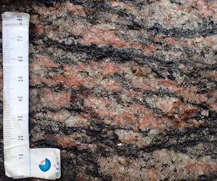 Troldstenen består af granitisk gnejs med feldspat og kvarts, der er trukket aflange, mellem bånd af biotit