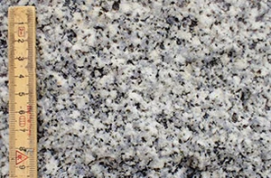 Bjergarten er meget lys og enskornet. Hovedmineralet er mælkehvid feldspat. Heri ses lys grå kvarts med et blåligt skær