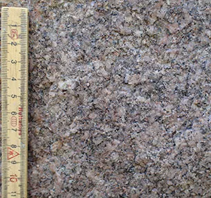 Volstrups kæmpesten består af mellemkornet bleg rød granit med felter af mere grovkornet granit