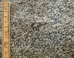 Bjergarten er meget lys og enskornet. Hovedmineralet er mælkehvid feldspat. Heri ses lys grå kvarts og brun kvarts