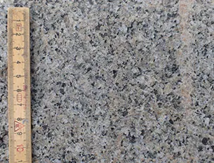 Stenen er mellemkornet og homogen med granittens tre mineraler: Blegt rød kalifeldspat, hvid plagioklas og glasagtigt kvarts