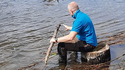 Mand sidder i vandkanten