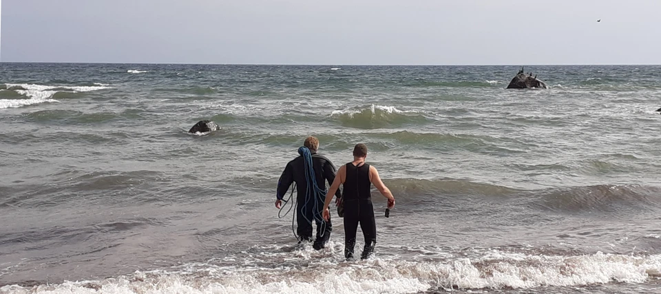 To mænd i vand for at måle Tøveldestenen