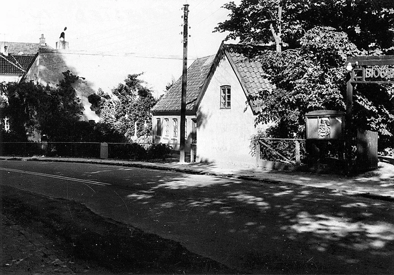 Kigger man godt efter, kan man til højre i billedet se indgangen til biografen. Den lå lidt tilbagetrukket på Mårumvej 1B i Græsted. Billedet er fra 1963, hvor bygningen blev solgt. I dag er der privat beboelse.