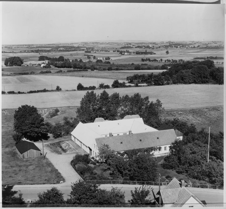 Ramsagergård i Græsted, 1953. Gården var kendt for sine store grusgrave, som Kommunen i mange år benyttede sig af. Det var særligt den type billeder, som Sylvest Jensen solgte mange af. Foto: Sylvest Jensen Luftfoto / Det Kongelige Bibliotek