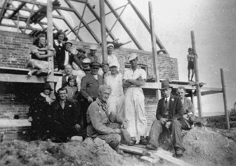 Rejsegilde på Valbyvej 2 i Græsted, ca. begyndelsen af 1940’erne. Her byggede Luft-Pedersen og Ellen et hus, Villa ”Dan”. Vi formoder, at Luft-Pedersen sidder midt i billedet med kasketten, og at Ellen også er med på billedet. Kontakt gerne arkivet med flere oplysninger.