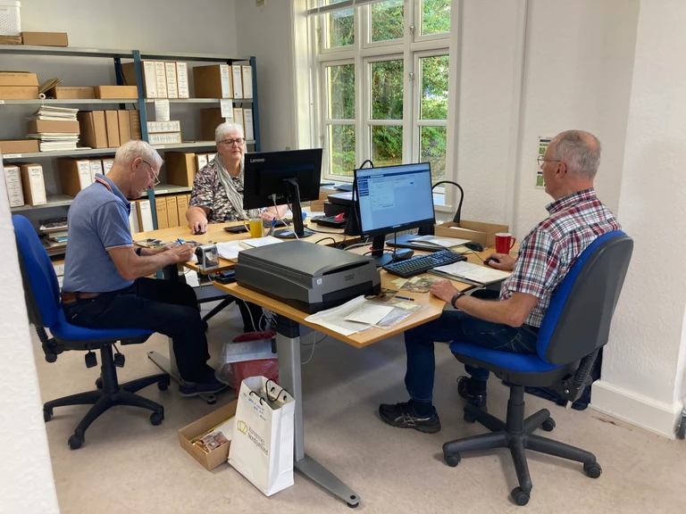 Ruth, Willy og Erik sidder og sorterer, scanner og registrerer billeder i Arkibas.