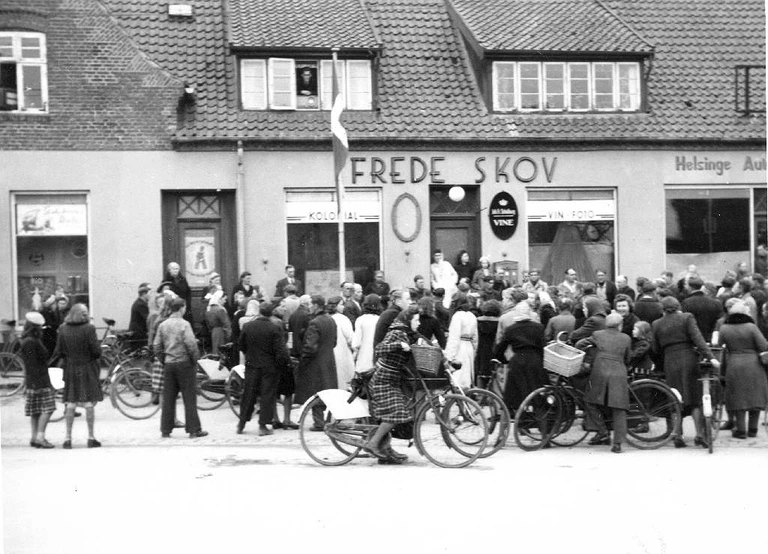 Borgere i Helsinge lytter til de seneste nyheder fra en radio placeret i et vindue, 5. Maj 1945. 