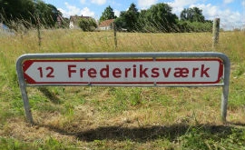 Eksempel på rød hvidt skilt som vejvisning til by