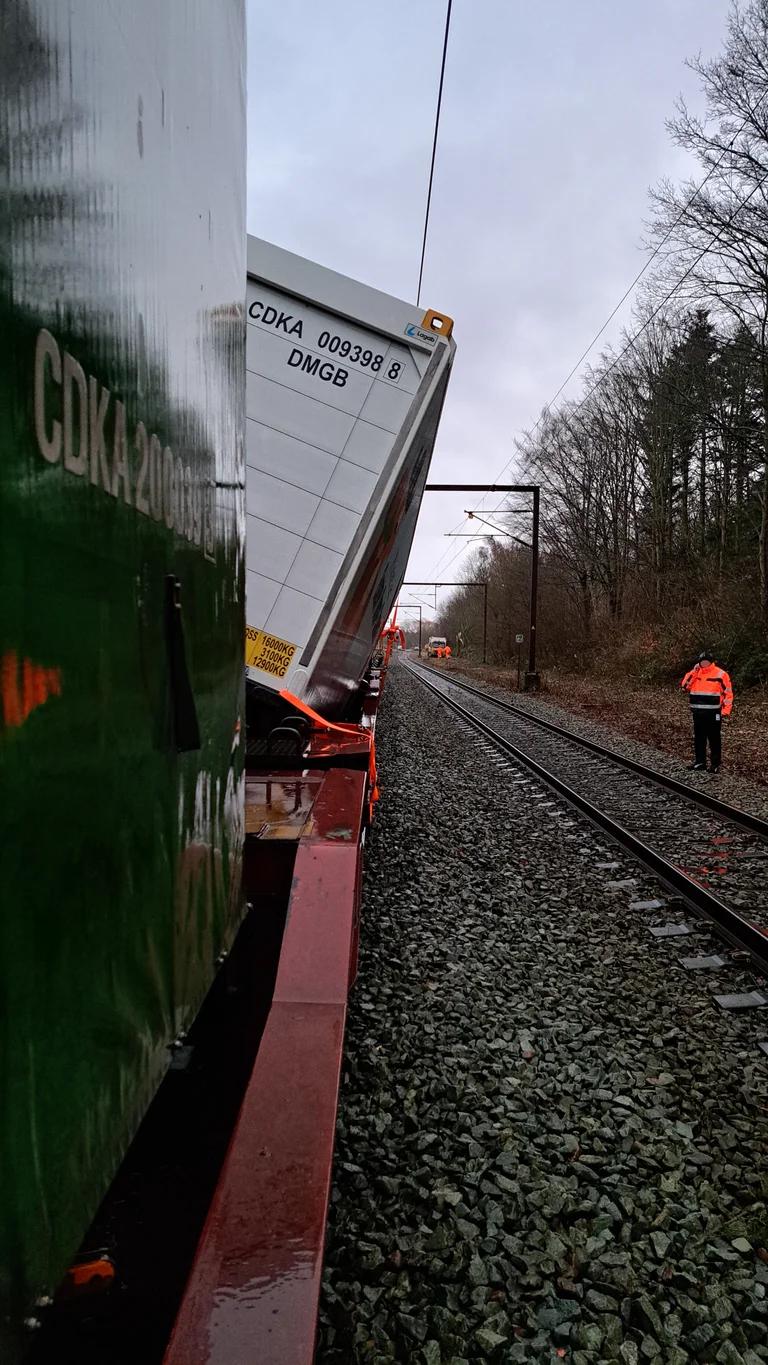 Fotoet viser togets højre side, hvor det kæntrede veksellad ses stikke ud over vognsiden.