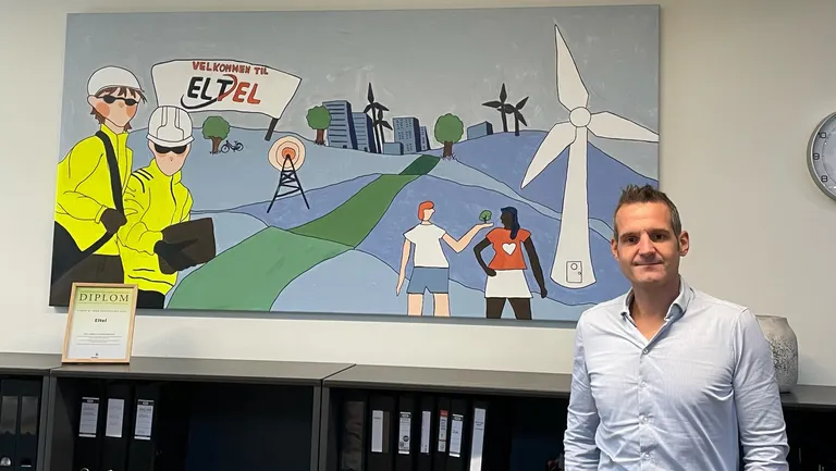 COO hos Eltel Networks, Jonas Vidar Kristiansen, foran maleriet som elever fra Herlev Billedskole har produceret ifm. Eltels modtagelse af Herlev Erhvervspris 2023.