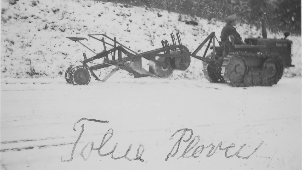 Billedet viser tolneploven trukket af en smal larvefodstraktor (formodentligt en Bristol 20), ca. 1950