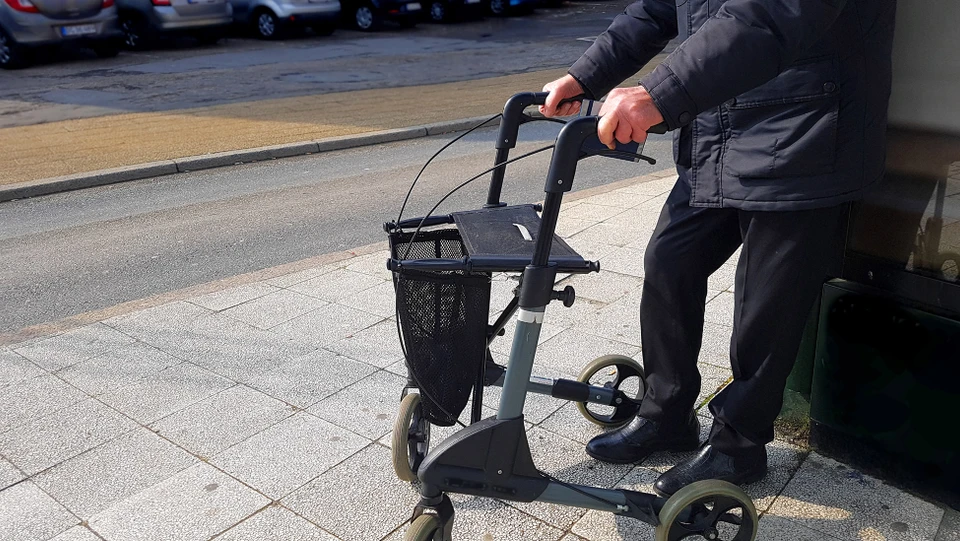 Billede af en mand der holder en rolator