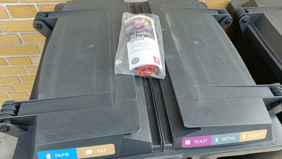 Billedet viser en rulle poser på en affaldscontainer