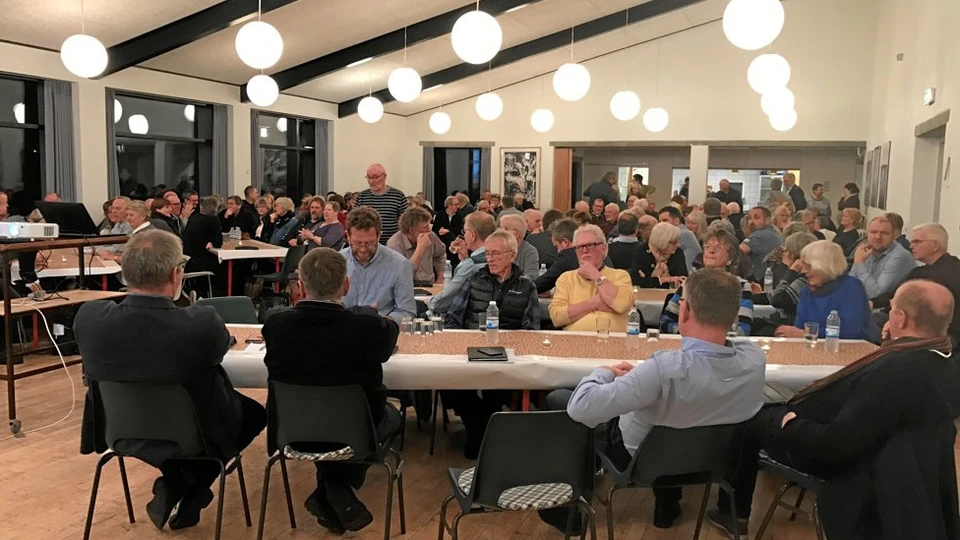 Mange mennesker der sidder til dialog møde i et oplyst lokale