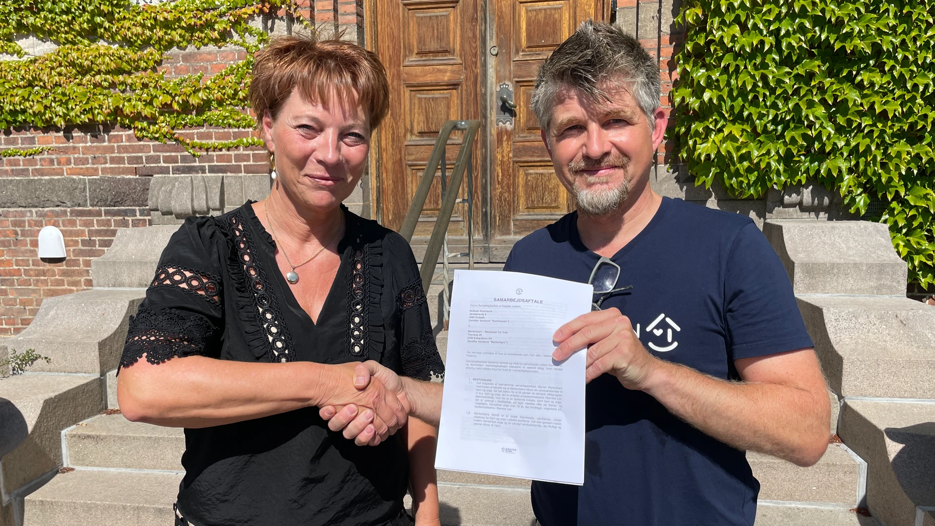 Helle Østergaard Stisen, chef for Børn og Familier hilser på Klaus Ljørring Pedersen, der er programchef hos Mentorbarn.