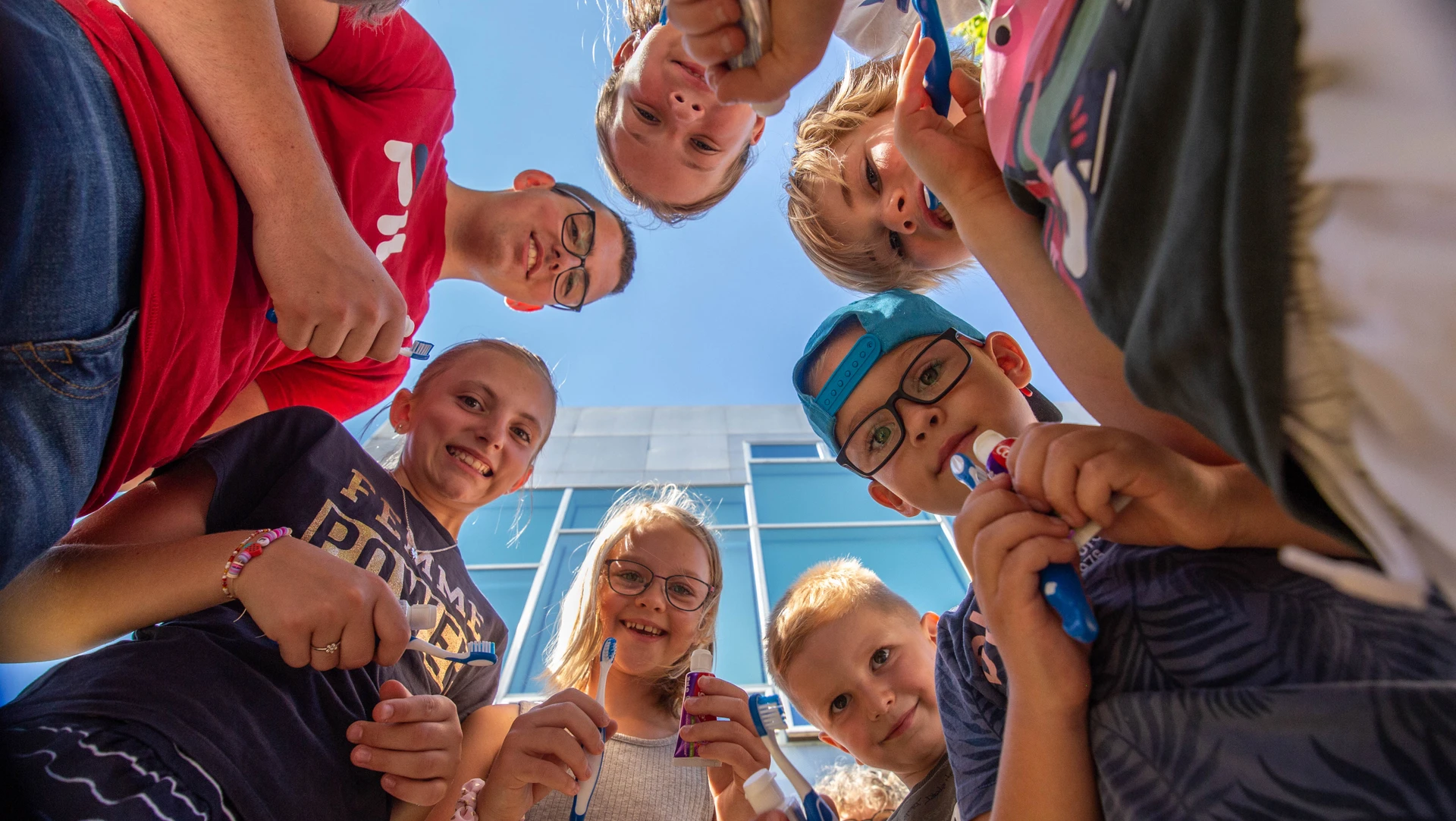 Børn der står i rundkreds med tandbørste og tandpasta i hænderne