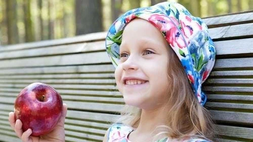 Smilende lille pige med æble