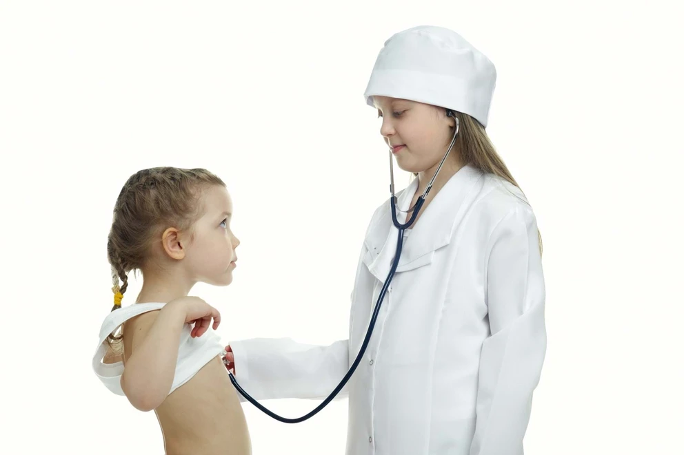 Pige med stetoskop lytter til en anden pige