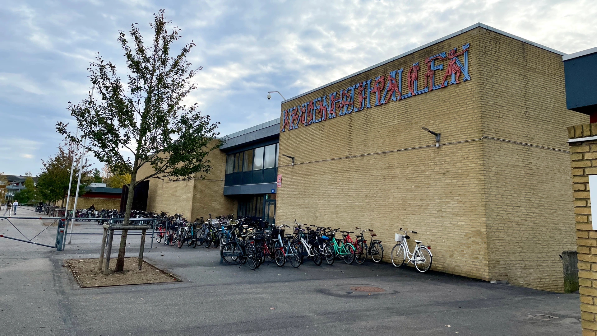 Forsiden af Frydenhøjhallen med en masse cykler parkeret foran