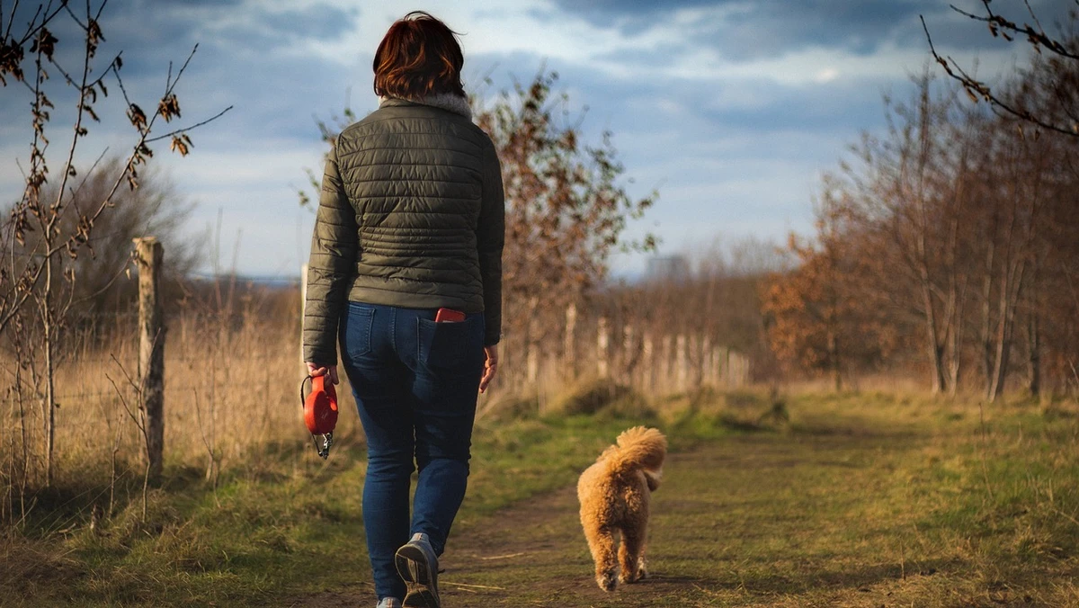 Kvinde går tur med sin hund
