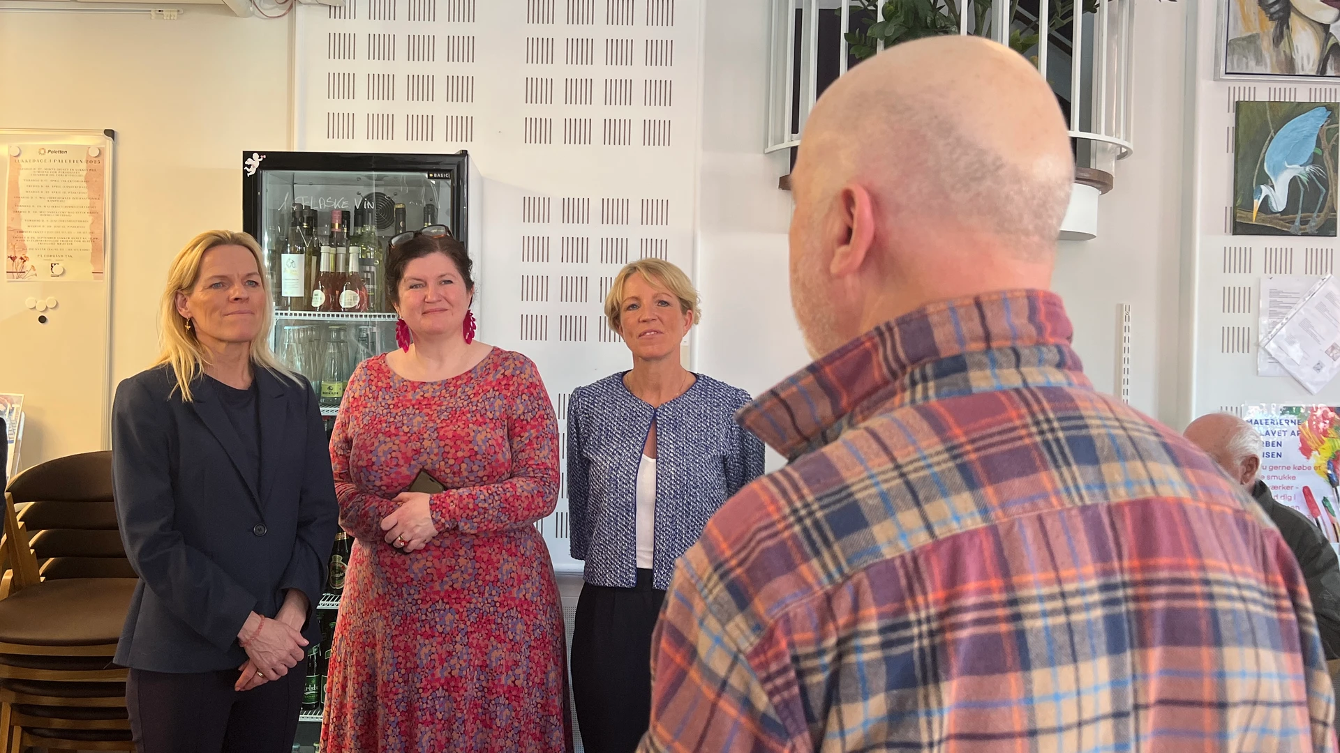 Ældreminister Mette Kierkgaard står sammen med leder af Paletten Betina Engelhardt Rasmussen og Centerchef for Sundhed og Ældre Christel Damgaard og snakker med en af Palettens mandlige brugere