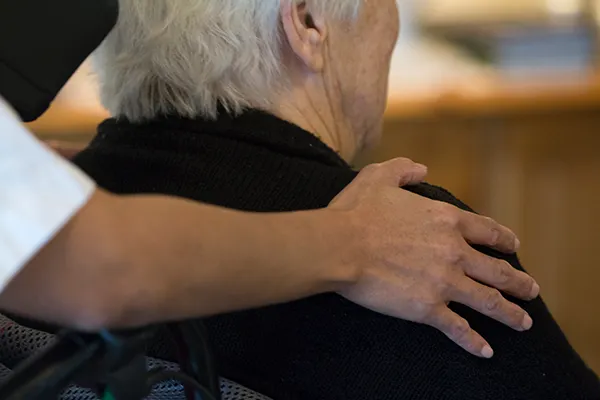 Arm om skulder på ældreperson