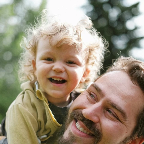 Far og barn smiler