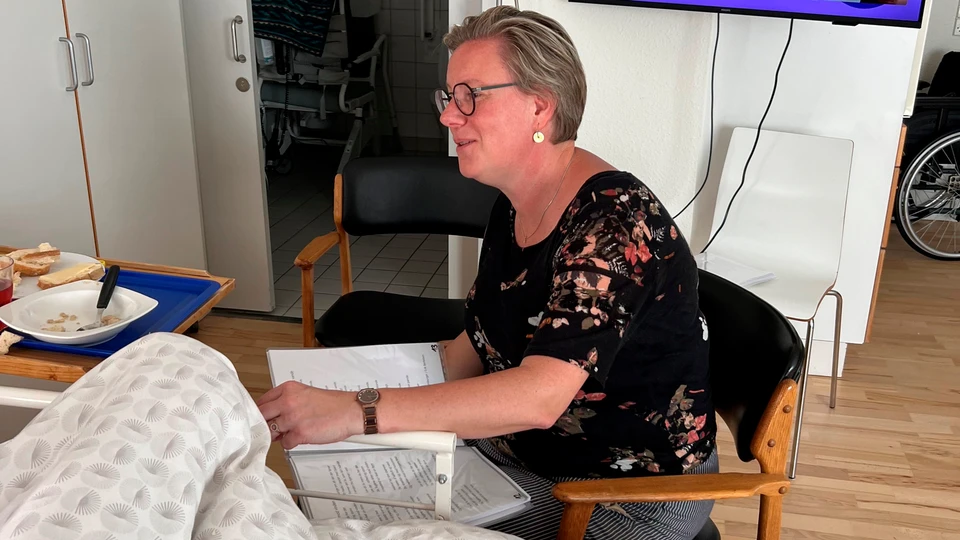 Kvinde synger for plejehjemsbeboer
