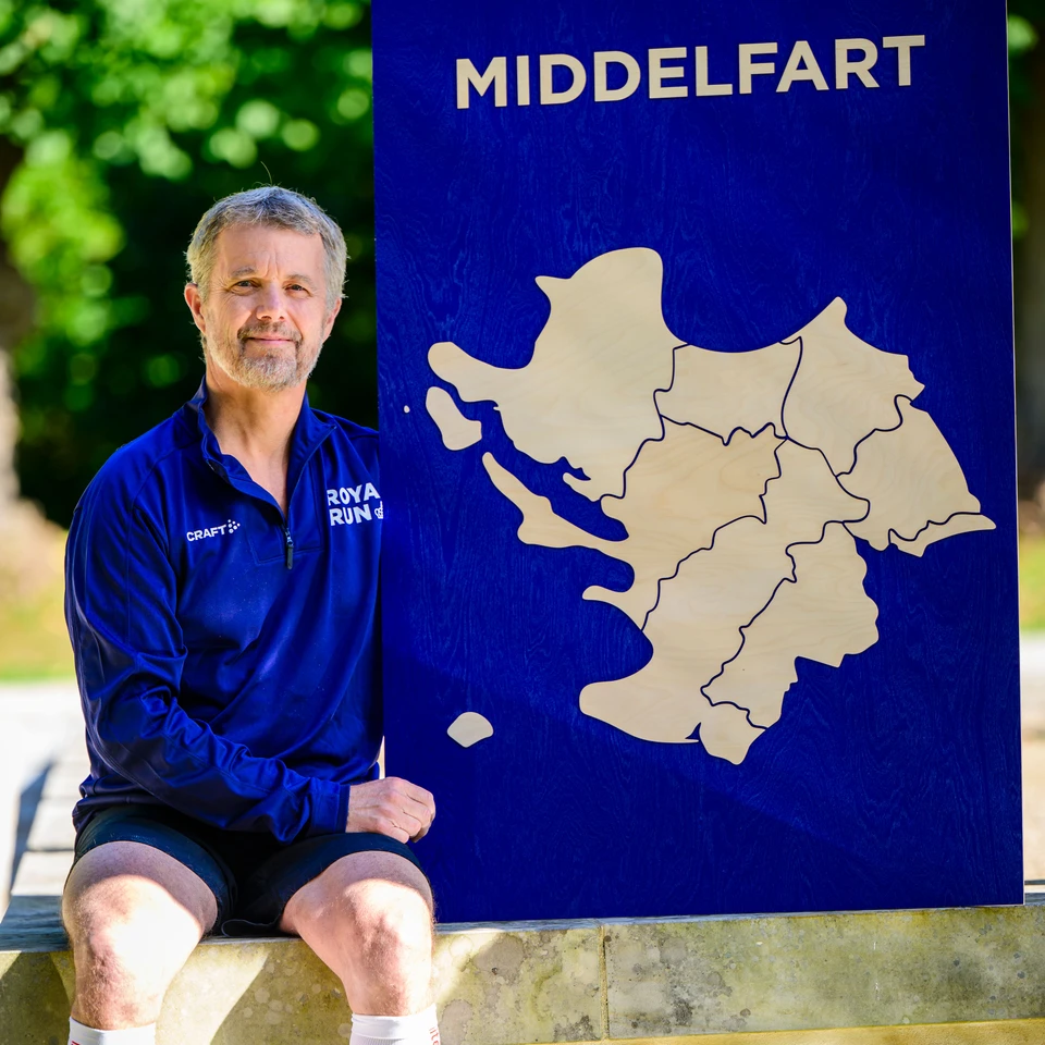 Hans Majestæt Kong Frederik med Royal Run skilt, der viser omridset af Middelfart Kommune