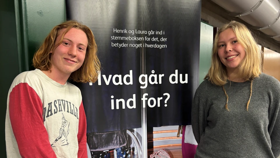 Jonas og Gunvor foran valgplakat med teksten 'Hvad går du ind for'?