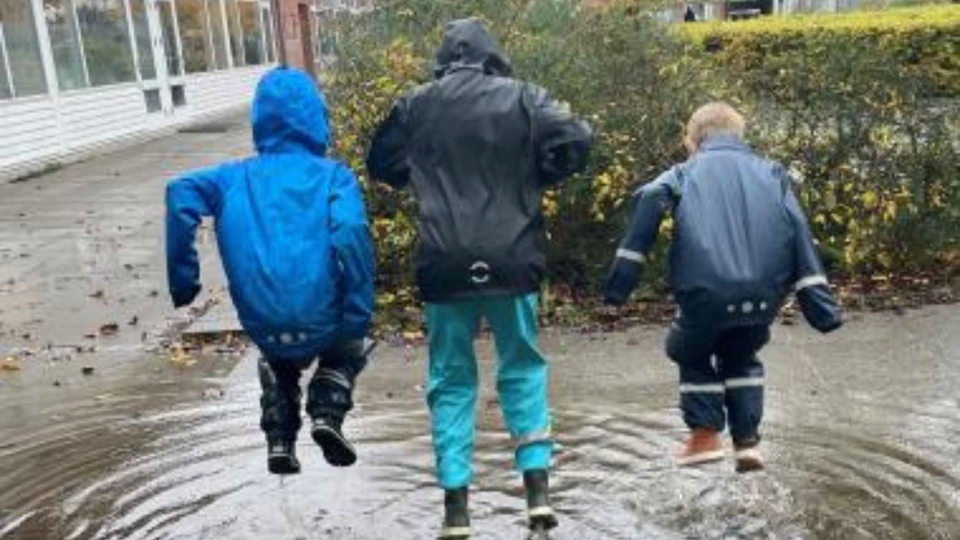 Børn hopper i vandpyt