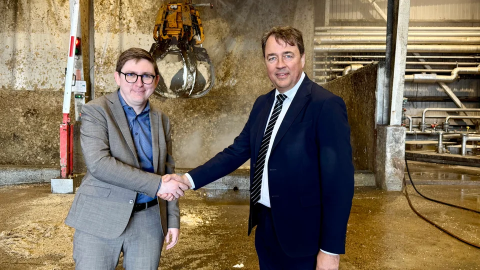 Borgmester Emil Blücher og Henrik Laursen, CEO i Bigadan glæder sig over en vellykket handel. I baggrunden ses en del af biogasproduktionen i form af pektinrester